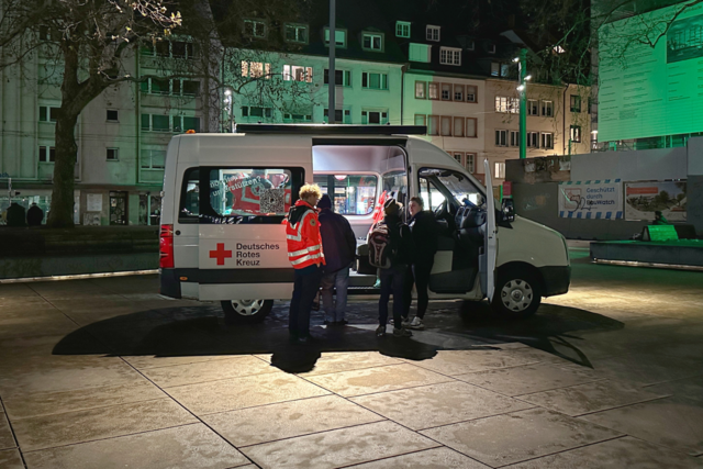 Der DRK-Kältebus Freiburg steht abends auf dem Platz der Alten Synagoge in Freiburg