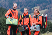 drei junge Sanitäterinnen schauen lächelnd in die Kamera, im Hintergrund sieht man den Schwarzwald