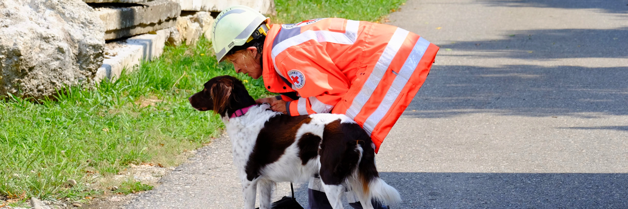 eine Rettungshundeführerin mit ihrem Hund
